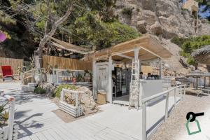 a restaurant on the beach with a mountain in the background at HOTIDAY Room Collection - Mattinata Faraglioni in Mattinata
