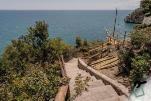 a set of stairs leading down to the ocean at HOTIDAY Room Collection - Mattinata Faraglioni in Mattinata