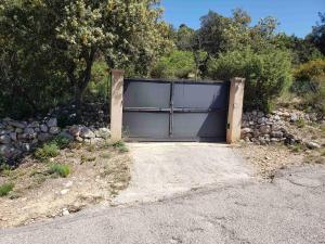 a large garage door in the middle of a driveway at Charmante petite maison de campagne in Jouques +2 photos