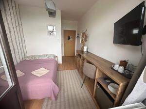 a small room with a purple bed and a desk at KAMERALNY przy promenadzie - pokoje in Charzykowy +67 photos