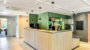 a kitchen with green cabinets and a counter top at Campanile NATURE - Montpellier Sud in Montpellier