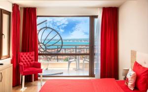 a bedroom with a red bed and a view of the ocean at Sea View Hills in Sveti Vlas +57 photos