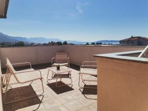 a patio with chairs and a table on a roof at Apartment Ivana in Kastel Novi