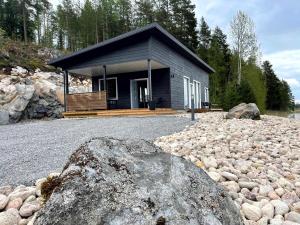 una casa con una gran roca delante de ella en Villa Längelmä, en Eräslahti
