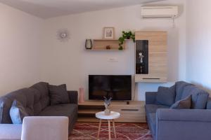a living room with two couches and a tv at Apartment Ivana in Kastel Novi