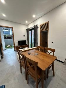 a dining room with a wooden table and chairs at Villa Mecca in Batu