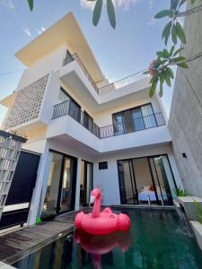 a house with a swimming pool in front of a house at Villa Mecca in Batu