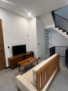 a living room with a couch and a tv at Villa Mecca in Batu