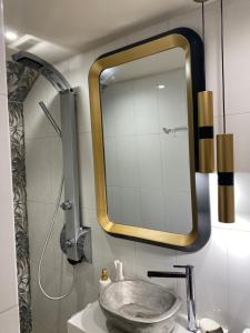 a bathroom with a sink with a large mirror at Happinest Private Apartment II in Kalymnos +14 photos