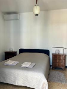 a bedroom with a bed with two towels on it at Casa Vintage in Alassio