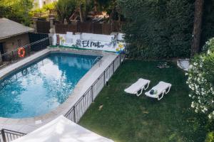 an overhead view of a swimming pool with two lawn chairs at EL MOTIVO in Cercedilla
