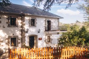 a white house with a wooden fence in front of it at EL MOTIVO in Cercedilla