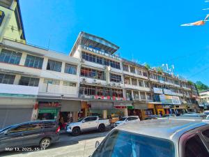 a large building with cars parked in front of it at Hotel O Malaysia Hotel in Sandakan