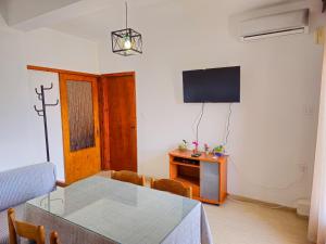 a dining room with a table and a television at Idyllic Escape Apartment in Gomátion