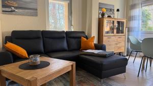 a living room with a black couch and a table at Zempin Ostseepark WE 10 _Insel Use in Zempin