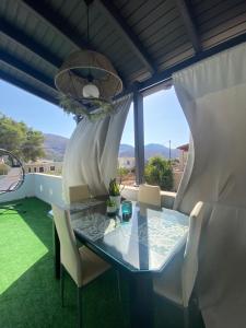 a dining room with a glass table and chairs at Happinest Private Apartment II in Kalymnos
