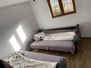 two beds sitting in a room with a window at Chalet Jelovica in Berane
