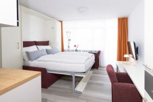 a bedroom with a white bed in a room at Huber Living in Germering