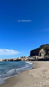 a beach with footprints in the sand and the ocean at Spinuzza relax in Cefalù