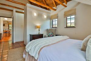 a bedroom with a white bed and a living room at Plum Tree Cottage in McGregor