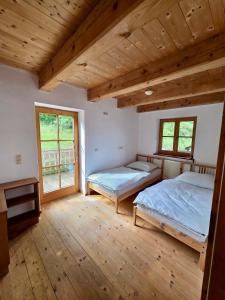 two beds in a room with wooden floors and windows at Ferienwohnung Landliebe in Dießen am Ammersee