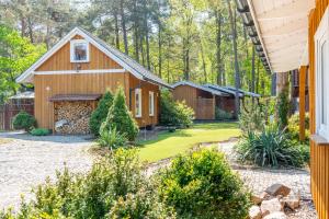 a home with a barn with a yard at Domki Pogorzelica in Pogorzelica