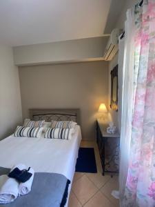 a bedroom with a bed and a table with a lamp at Happinest Private Apartment II in Kalymnos