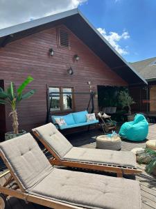 a patio with two lounge chairs and a blue couch at KaSper River House in Ledine