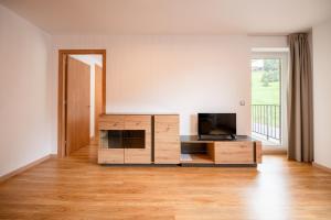 a living room with a television and a wooden cabinet at Barthe Holidays I Acogedor apartamento en Arinsal 6PAX a pie de pistas I Balcón con vistas y parking I Madness in Arinsal
