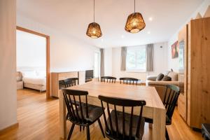 a kitchen and living room with a wooden table and chairs at Barthe Holidays I Acogedor apartamento en Arinsal 6PAX a pie de pistas I Balcón con vistas y parking I Madness in Arinsal