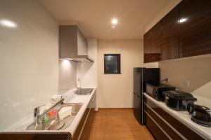 una cocina con fregadero y refrigerador en MONOMINA Vacation Villa, en Yufu 13 fotos más