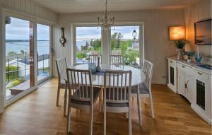 a dining room with a table and chairs and windows at 2 Bedroom Cozy Home In Larkollen in Laurkollen