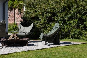 a couple of chairs and a table in a yard at La Maison Du Meunier in Dannes
