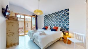a bedroom with a large bed and a tv at Le Tinailler Grand Standing au Cœur des Vignes in Prissé