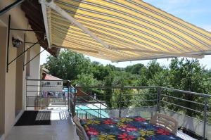 a balcony with a bed and a large umbrella at Gite de la combe in Désandans