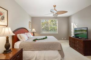 a bedroom with a bed and a flat screen tv at Ko Olina Kai 1059F in Kapolei