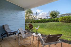 a patio with chairs and a table and a lawn at Ko Olina Kai 1059F in Kapolei