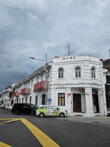 a white building with cars parked in front of it at The Harbour by Moonknight in George Town