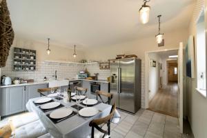 a kitchen with a table and a refrigerator at Danes House 4 in Aldeburgh
