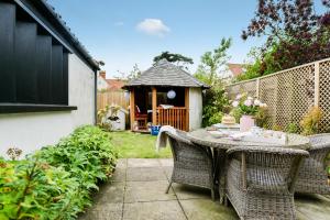 a table and chairs in a backyard with a gazebo at Danes House 4 in Aldeburgh