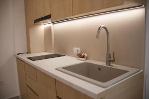 a kitchen with a sink with a light above it at Alpesa Apartments in Budva +49 photos