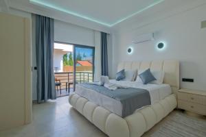 a bedroom with a large white bed with a balcony at ADER DOĞA Villaları 6 in Zikirciler +35 photos