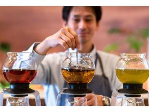 福岡市にあるThe OneFive Terrace Fukuoka - Vacation STAY 33419vのワイングラス二杯の後ろに立っている男