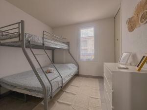 ル・バルカレスにあるMaison vacances proche de la merの二段ベッド2台と机のある寝室