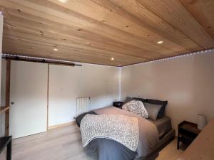 a bed in a room with a wooden ceiling at ÉTAPE Chambre 2 pers indépendante idéale avant ou après votre séjour en station in Aime La Plagne