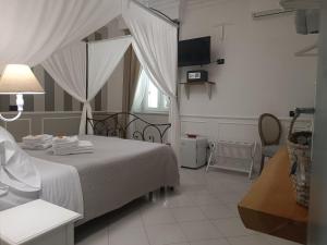 ein Schlafzimmer mit einem Bett und einem Fernseher darin in der Unterkunft Relais Tiaré Bed and Breakfast in Bacoli