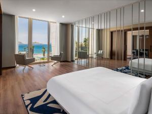 a bedroom with a bed and a view of the ocean at Swissôtel Resort Bodrum Beach in Turgutreis