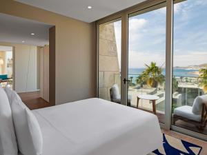 a bedroom with a bed and a view of the ocean at Swissôtel Resort Bodrum Beach in Turgutreis