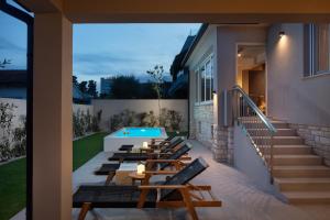 a row of chairs and a swimming pool on a house at Villa Veg in Umag