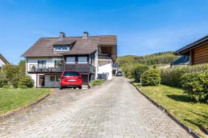a red truck parked in front of a house at Ferienwohnung im Elsetal in Plettenberg